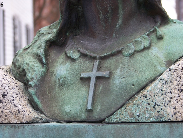 picture 6 green cross hanging from neck of a sculpture
