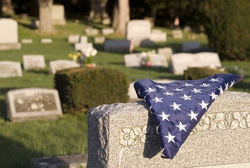 american flag on cemetery headstone